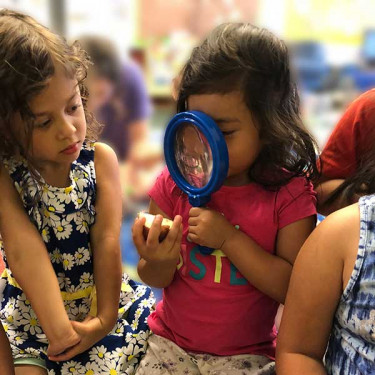 girl holding magnifying glass